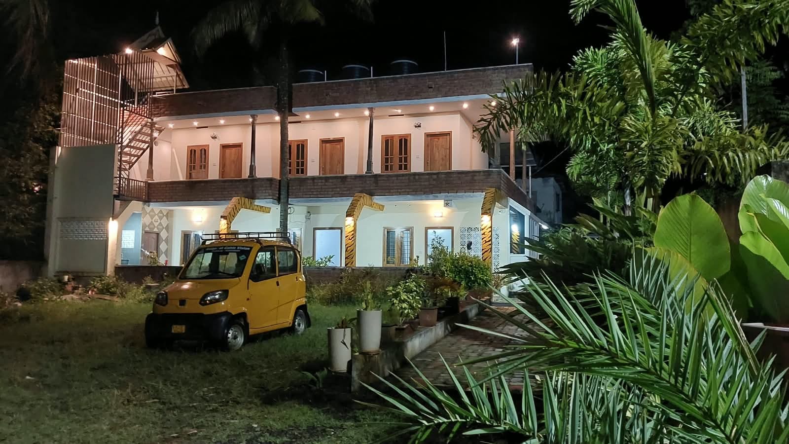 Euro Inn Homestay exterior at night, with illuminated rooms and garden plants.