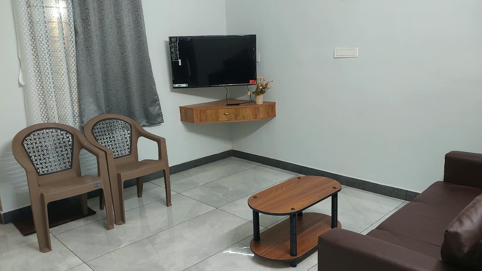 Living area with a sofa, chairs, coffee table and television.
