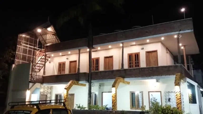 The illuminated homestay exterior at night.