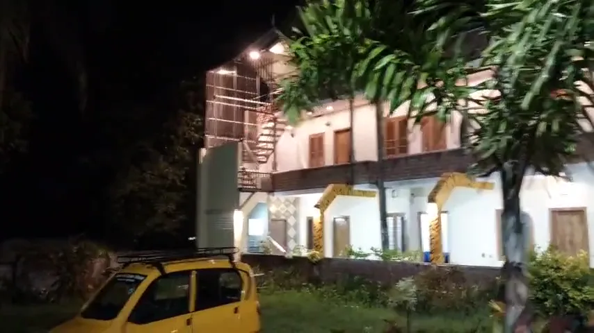 Homestay exterior with garden plants after sundown.